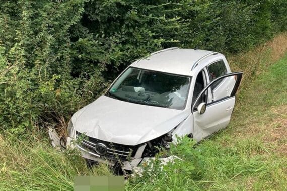Verunfallter VW Tiguan im Straßengraben, Unfallstelle, Polizei und Rettungsdienste in Aktion.