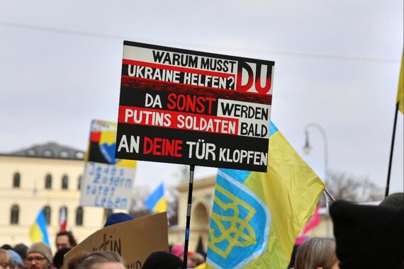 Protestierende Menschen auf einer Demo für die Ukraine, symbolisieren Besorgnis über Kriegsausweitung.