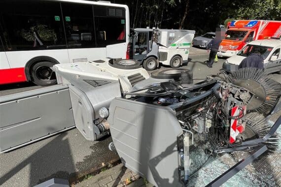 Unfall mit Kehrmaschinen und Linienbus an Haltestelle, Polizei vor Ort, beschädigte Haltestelle.