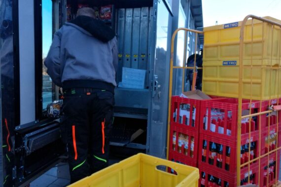 Getränkeautomat wird aufgefüllt; Symbol für Diskussion über Zuckersteuer und Gesundheitsthemen.