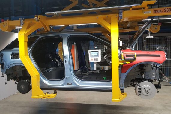 Elektroautos auf einem Produktionsband, mit Politikern, die Anreize zur Förderung fordern.