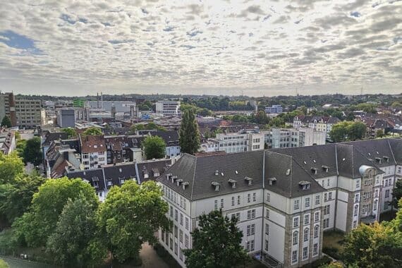 Panorama von Essen mit wechselhaftem Wetter, grauen Wolken und vereinzelten Schauern im Hintergrund.