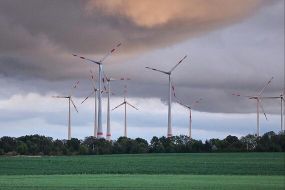 Stark bewölkter Himmel über Windrädern, mit leichten Regen- und Sonnenscheinanteilen.