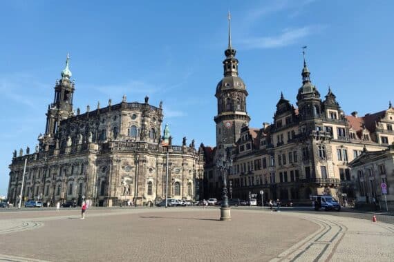 Sonnenbeschienener Theaterplatz in Dresden mit Menschen, die das schöne Spätsommerwetter genießen.