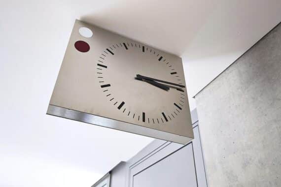 Eine große Wanduhr zeigt die Zeit 2:00 Uhr, symbolisiert die bevorstehende Zeitumstellung.