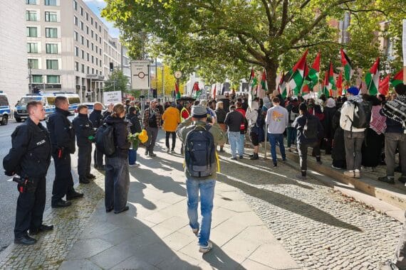 Zusammenkommen von Menschen, Proteste, Polizei, Spannungen, Farbschmierereien, Pyrotechnik, Auseinandersetzungen, Berlin.