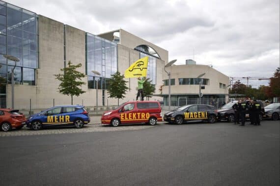 Greenpeace-Aktivisten protestieren mit Elektroautos vor dem Kanzleramt für E-Mobilität und Klimaschutz.