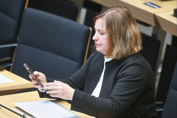 Tonka Wojahn diskutiert Ausbildungsvisa und Kontrollen, während sie auf Bildschirme blickt.