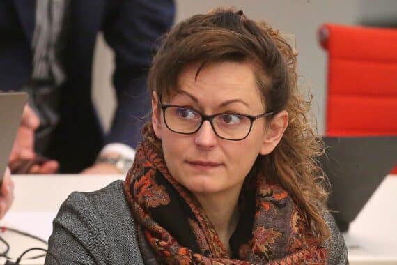 Hanka Mittelstädt bei einer Klimaschutzkonferenz, während Politiker an bedeutenderer Veranstaltung teilnehmen.