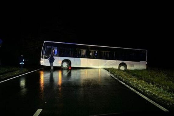 Festgefahrener Bus auf Landesstraße, Querstellung, keine Fahrgäste, Polizei und Kran im Einsatz.