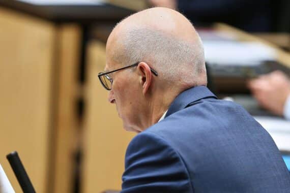 Peter Tschentscher steht vor dem Elbtower; Symbol für umstrittene politische Entscheidungen in Hamburg.