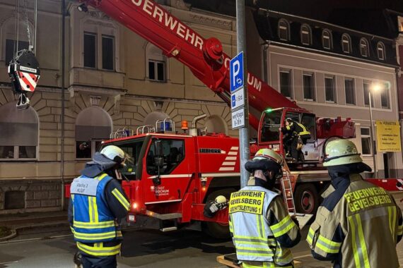 Teile des Daches eines Wohnhauses werden sorgfältig abgetragen, Rettungskräfte im Einsatz.