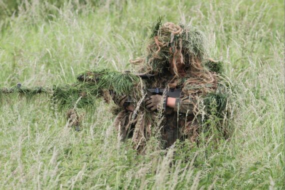 Getarnter Soldat symbolisiert Streit um Wehrdienstreform zwischen Union und SPD im Bundestag.