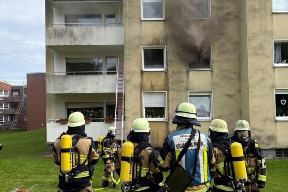 Feuerwehr im Einsatz bei Wohnungsbrand, Rettung von Miter wohnen, schwarze Rauchentwicklung sichtbar.