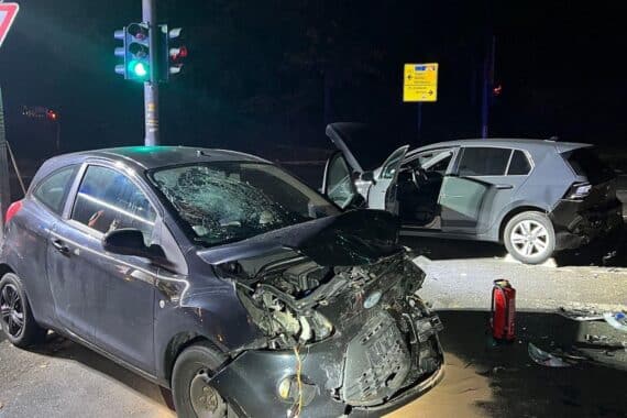 Feuerwehrleute bei nächtlichem Einsatz, Fahrzeuge im Einsatz, Rettungskräfte sichern Unfallstelle.