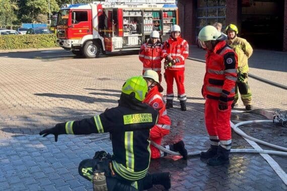 Feuerwehrübung: angehende Notfallsanitäter lernen Brandbekämpfung und hydraulische Rettungstechniken.
