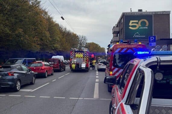 Feuerwehr im Einsatz bei Wohnungsbrand, löschend und kontrollierend auf Balkon und Wohnung.