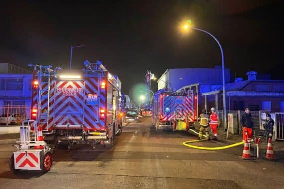 Feuerwehr im Einsatz zur Brandbekämpfung in leerstehendem Gebäude, dichter Rauch sichtbar, Einsatzkräfte aktiv.