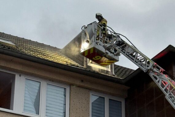 Dachstuhlbrand, Feuerwehr im Einsatz, Flammen und Rauch über einem Wohnhaus in Mettmann.