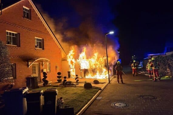 Brand in Leichtbaugarage, Feuerwehr im Einsatz, betroffene Doppelhaushälfte, verletzte Personen betreut.