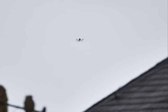 Eine Drohne fliegt über eine Stadt, symbolisiert moderne Polizeitechnologie und Sicherheitsmaßnahmen.