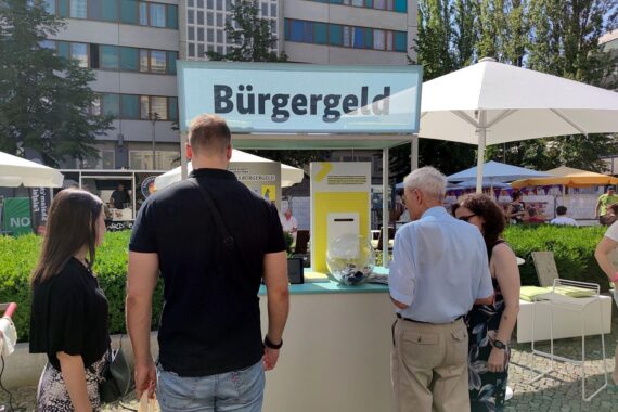 Infostand zum Bürgergeld mit Passanten, die sich über Reformen und Leistungen informieren.