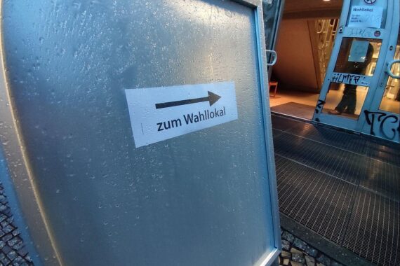 Wahllokal mit Wählern, symbolisiert demokratische Prozesse und bevorstehende Wahlkreisreform in Niedersachsen.