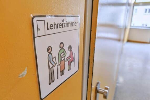 Genderzeichen vor einem Lehrerzimmer, symbolisiert Vielfalt und Inklusion in der Bildung.
