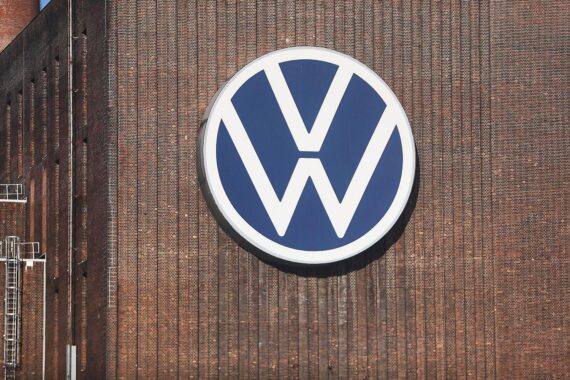 VW-Werk mit Mitarbeitern im Fokus, symbolisiert juristische Auseinandersetzungen und Tarifthemen.