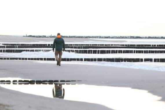 Strandlandschaft mit Menschen, die Gemeinsamkeit und Unterstützung in der Einsamkeit symbolisieren.