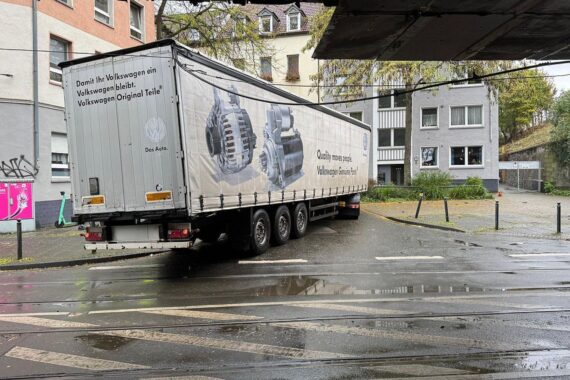 Ein beschädigter Strommast nach Lkw-Unfall, Feuerwehr im Einsatz, Verkehrschaos in Dortmund.