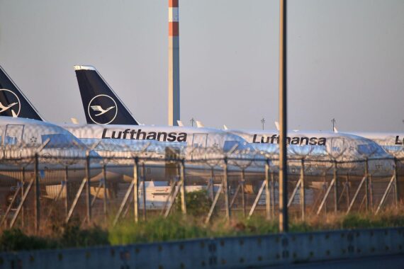 Lufthansa-Flugzeuge am Flughafen, symbolisieren die bevorstehenden Stellenabbau-Maßnahmen in der Verwaltung.
