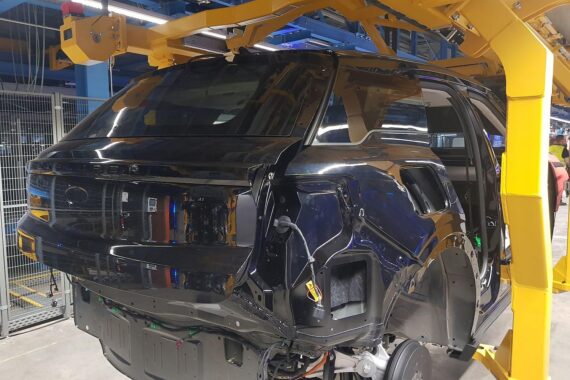 Bild zeigt moderne Autos in einer Produktionslinie, symbolisiert Herausforderungen und Innovation der Autoindustrie.