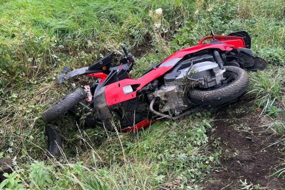 Ein schwer beschädigtes dreirädriges Fahrzeug im Straßengraben nach einem schweren Unfall.