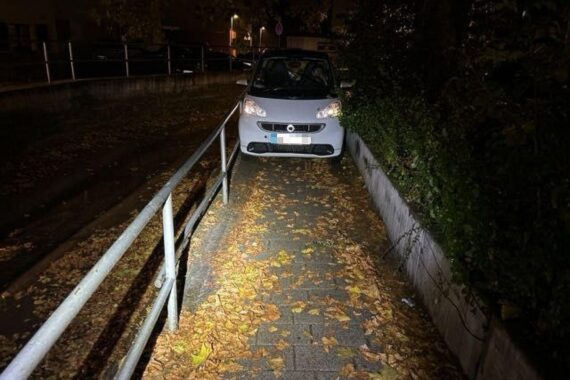 Festgefahrener Smart auf Gehweg, Feuerwehr befreit älteren Fahrer in engen Platzverhältnissen.