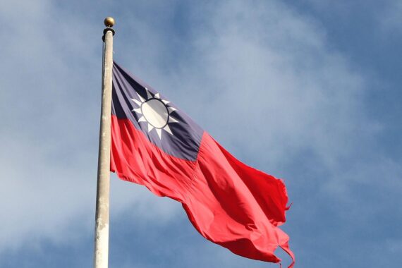 Taiwan-Flagge vor wirtschaftlichem Hintergrund, symbolisiert Zusammenarbeit und geopolitische Bedeutung.