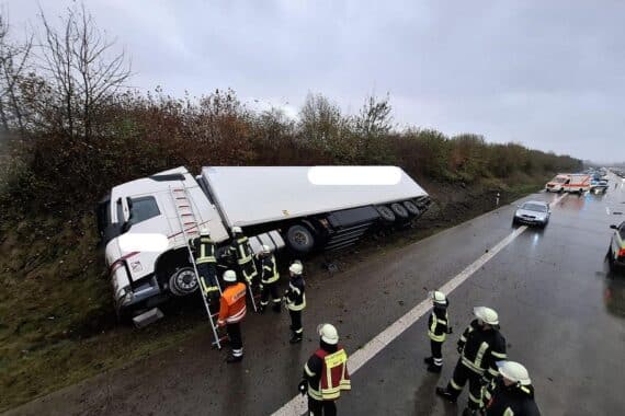 Unfallstelle auf Autobahn mit umgekipptem Lkw und Einsatzkräften der Feuerwehr.