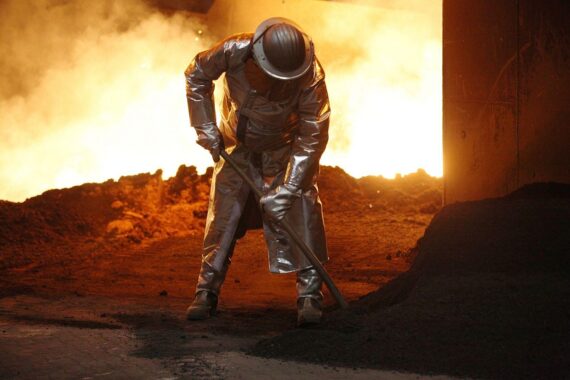 Industrieanlagen mit rauchenden Schornsteinen, symbolisierend den Trend zur Produktionsverlagerung ins Ausland.