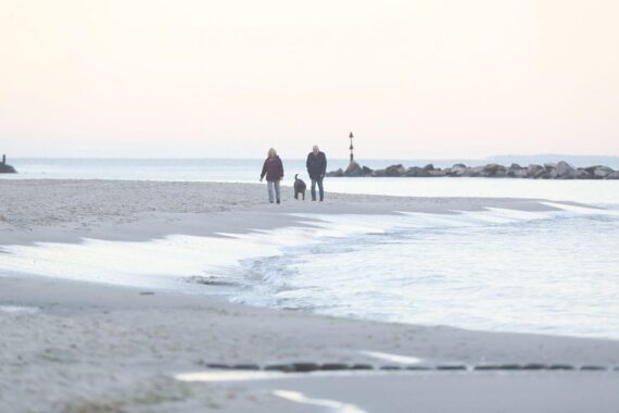 Sonniger Strand in Mecklenburg-Vorpommern, frostige Nächte, klare Himmel, milde Temperaturen tagsüber.