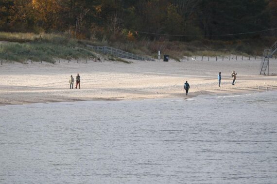 Dicht bewölkter Himmel über einem Strand, mit windigem und regnerischem Wetter.