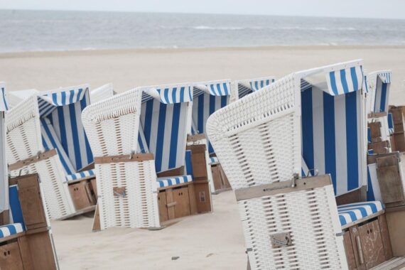 Herbstlicher Strand bei Sonnenwetter, Strandkörbe im Vordergrund, angenehme Temperaturen, klare Himmel.