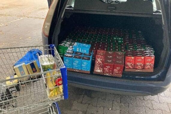 Zwei Männer stehlen großen Einkaufswagen voller Kaffee aus Supermarkt, Polizei nimmt einen fest.