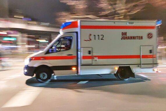 Nachtszenario mit einem Rettungswagen, der bei einem Unfall auf einer Straßenbahnlinie eingreift.