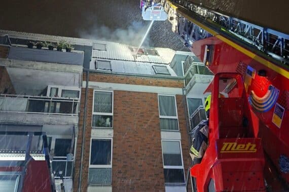 Drehleiter im Einsatz, Feuerwehr kämpft gegen Dachgeschossbrand, nächtliche Rettungsaktion, Schnee.