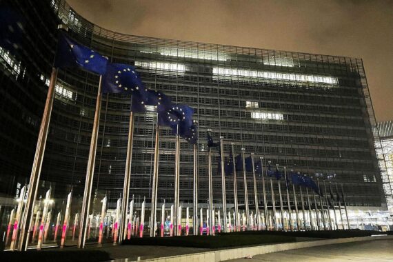 EU-Fahnen im Vordergrund, symbolisieren den abgeschwächten Klimakompromiss der Mitgliedsstaaten.