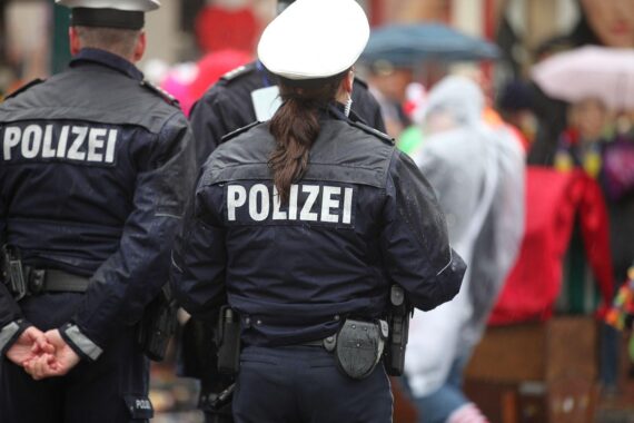Polizisten in Karnevalskostümen überwachen Sicherheitsmaßnahmen auf festlichen Umzügen und Feiern.