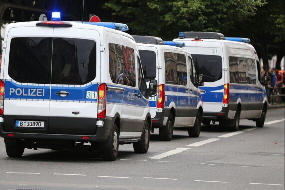 Polizeiautos bei einer Razzia gegen internationale Betrugs- und Geldwäschenetzwerke, festgenommene Verdächtige.