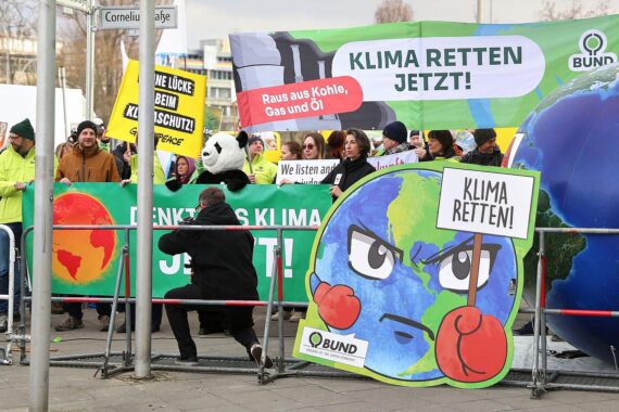 Demonstranten mit Plakaten, die für Klimaschutz und dringende Maßnahmen gegen die Erderwärmung plädieren.
