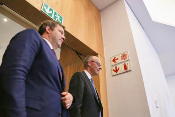 Lars Klingbeil und Friedrich Merz diskutieren, während Bürger an möglichen Koalitionsbruch denken.