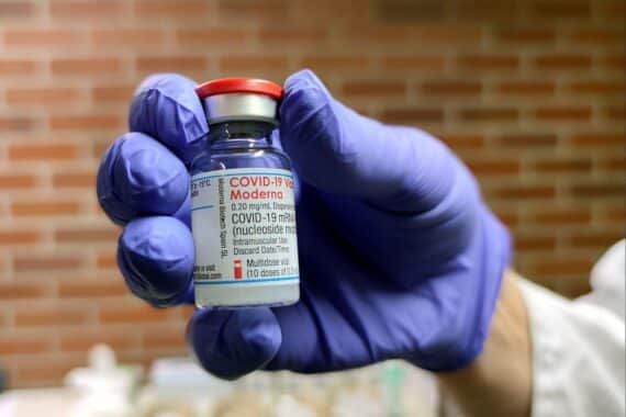 Moderna-Impfampulle symbolisiert Fortschritte in der Impfstoffentwicklung nach schwierigen Jahren.